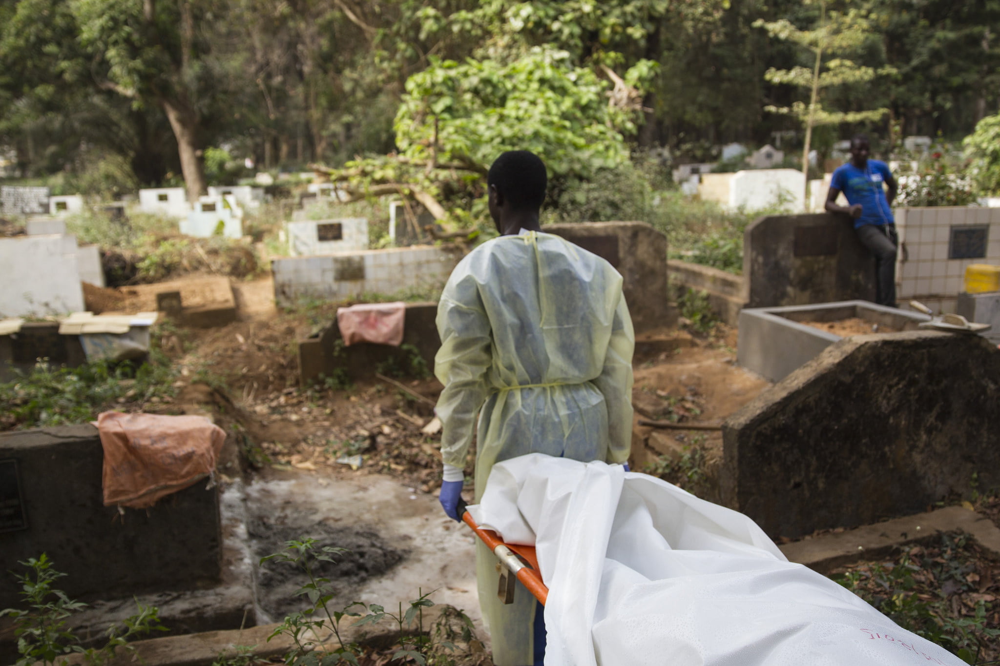Burial teams of volunteers in Guinea, wearing full personal protective equipment and working in teams of seven, carry the body of a 40 year-old woman who died from Ebola virus from the MSF Treatment Center at Donka Hospital to the Conakry Cemetary for a safe burial.