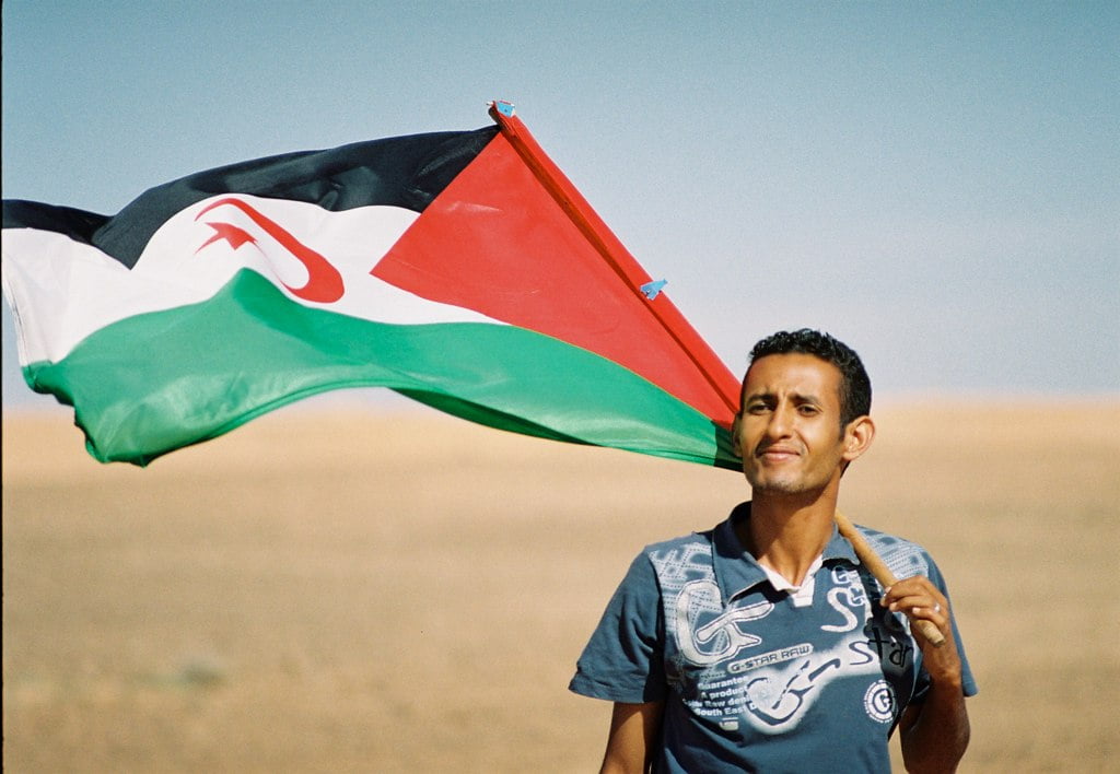 A Sahrawi man with the Western Saharan flag. Photo by: Michele Benericetti
