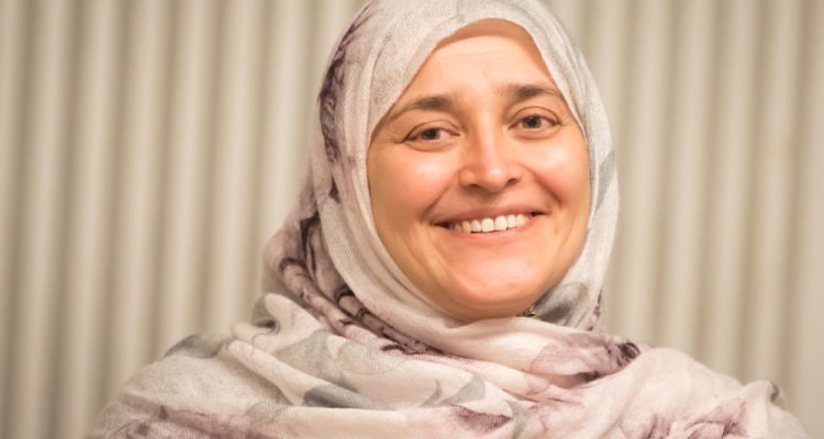 Jamila Afghani, NGO NECDO founder, and Aurora Prize winner smiles broadly in a traditional head scarf.